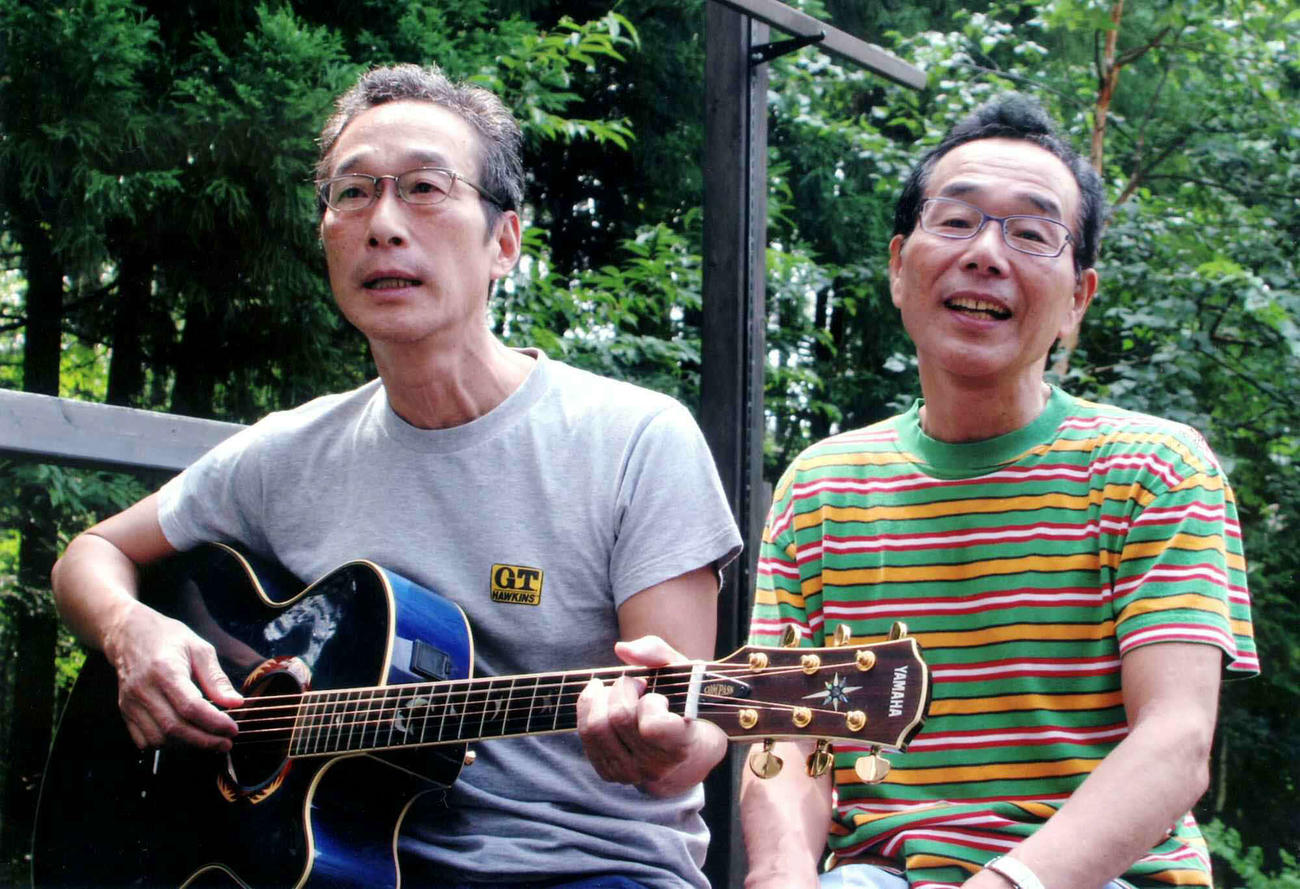 緑の中で「白いブランコ」を歌うビリー・バンバンの兄菅原孝（右）と弟菅原進（2005年8月撮影）