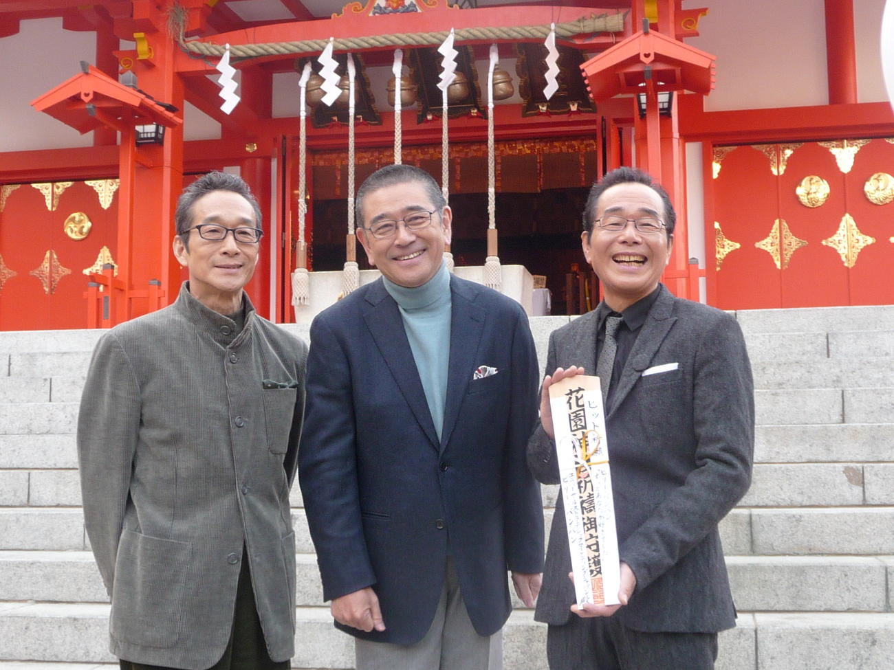 石坂浩二（中央）の応援を受けヒット祈願するビリー・バンバンの菅原進と菅原孝さん（右）（2011年1月）