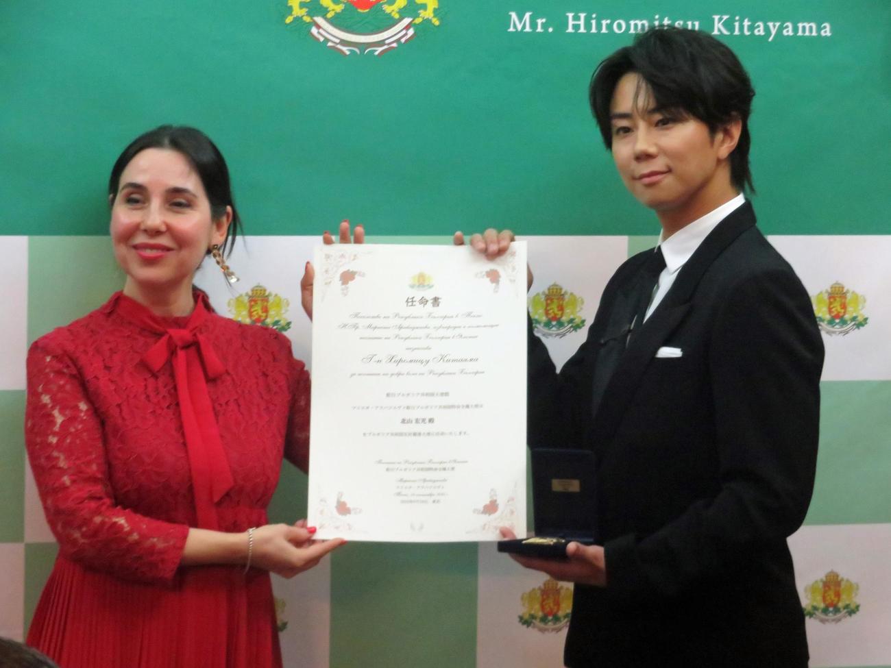特命全権大使マリエタ・アラバジエヴァ氏（左）から任命証を授与された北山宏光（撮影・川田和博）