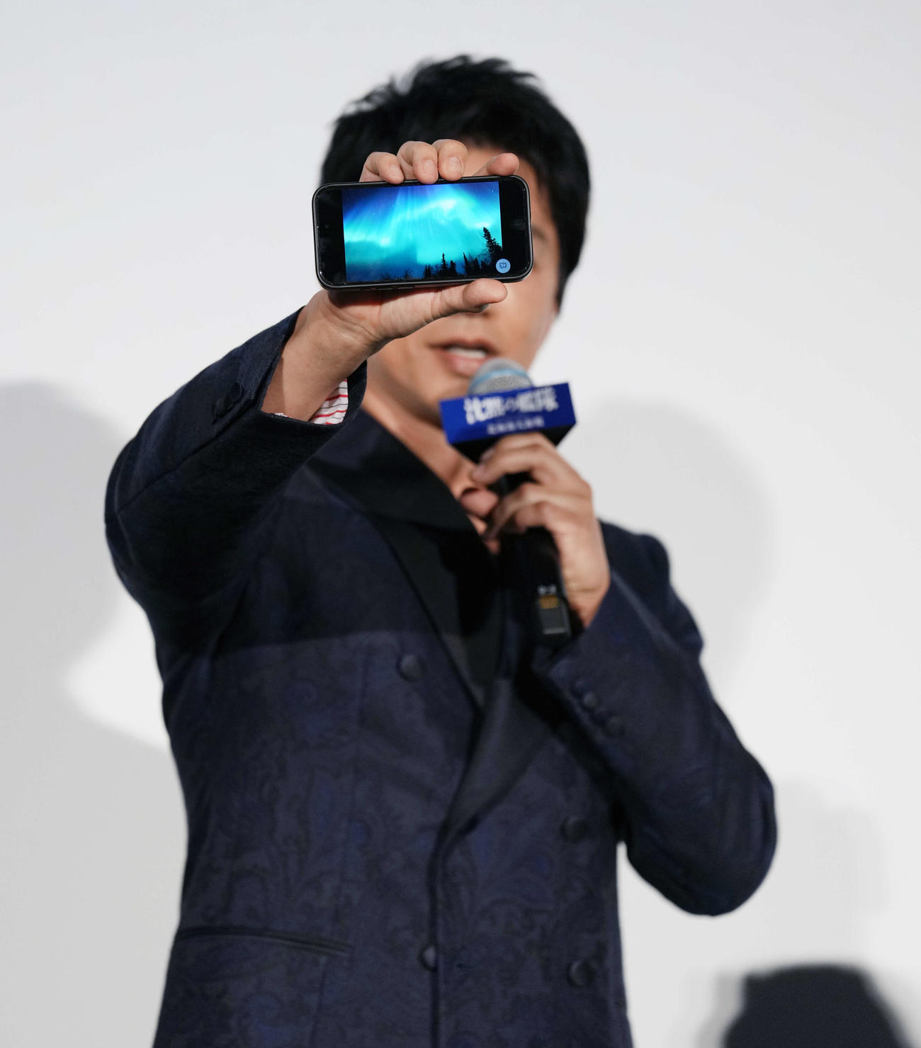 映画「沈黙の艦隊　北極海大海戦」初日舞台あいさつに登場し、北極で撮影したオーロラの写真を見せる大沢たかお（撮影・小島史椰）