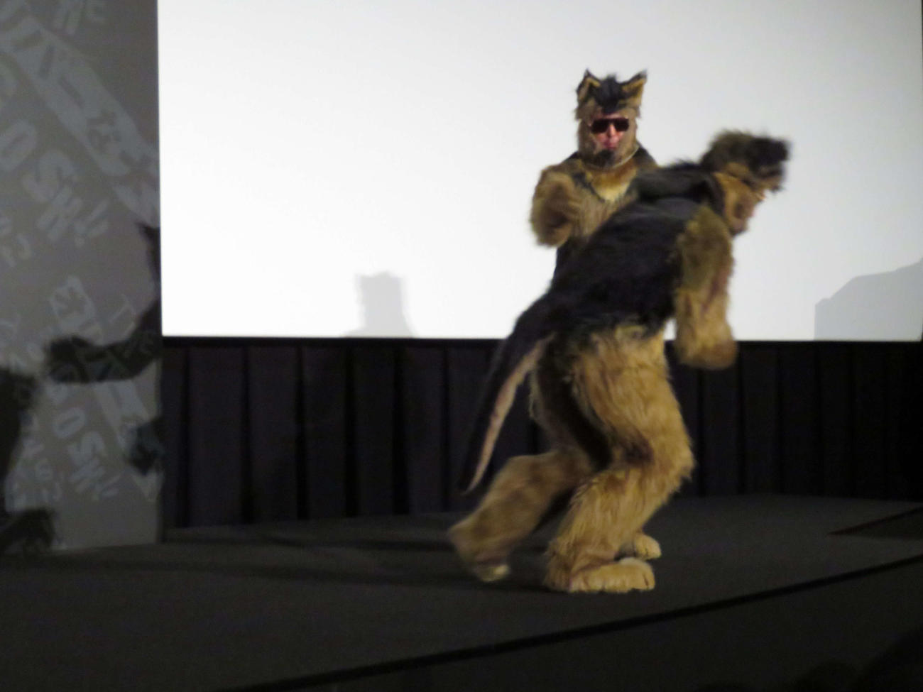 映画「THE　オリバーな犬、（Gosh！！）このヤロウ　MOVIE」初日舞台あいさつの壇上で、偽オリバー（手前）を追いかけるオダギリジョー扮するオリバー（撮影・村上幸将）