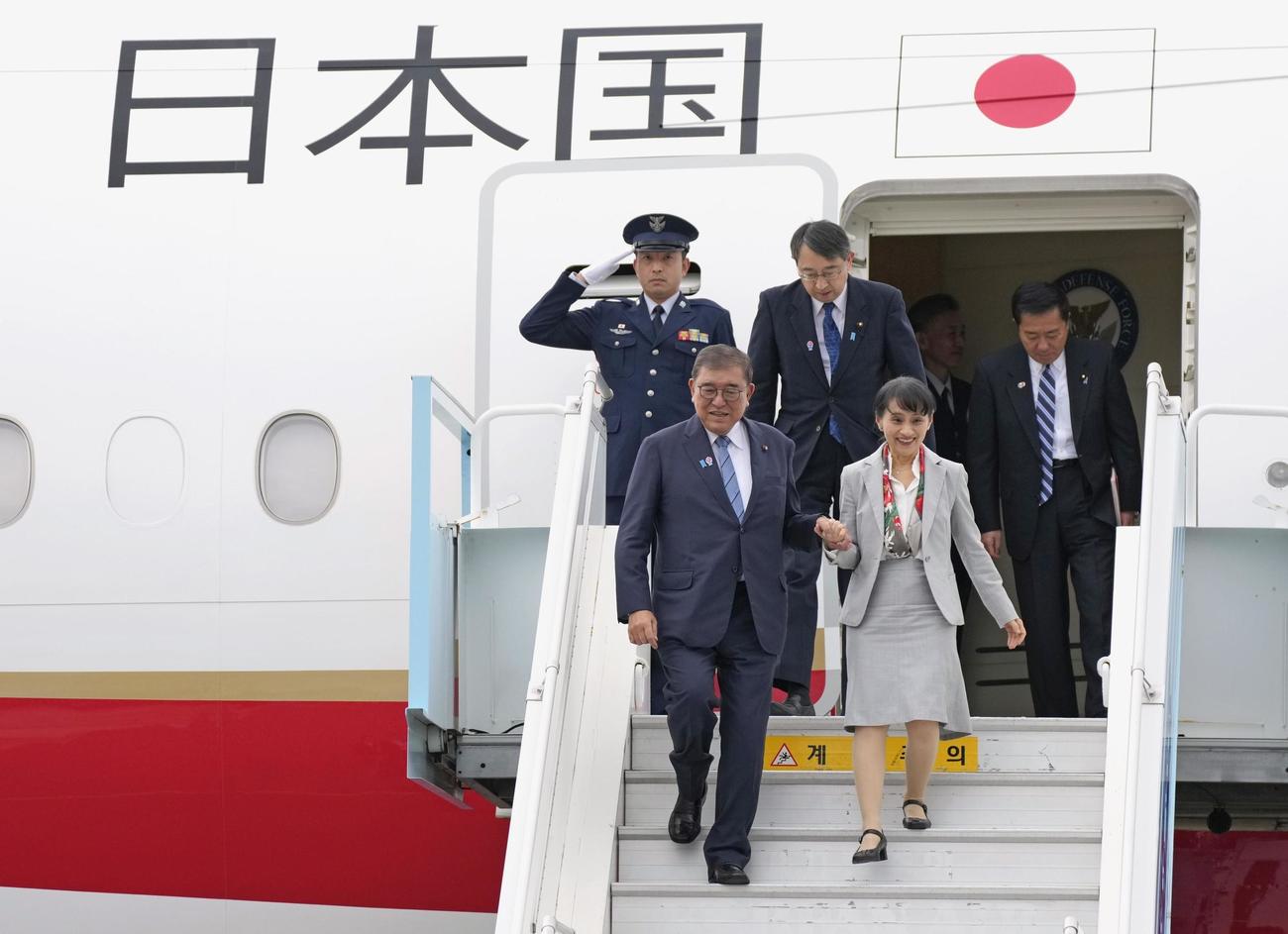 韓国・釜山の金海国際空港に到着した石破首相（手前左）。右は妻の佳子さん（共同）