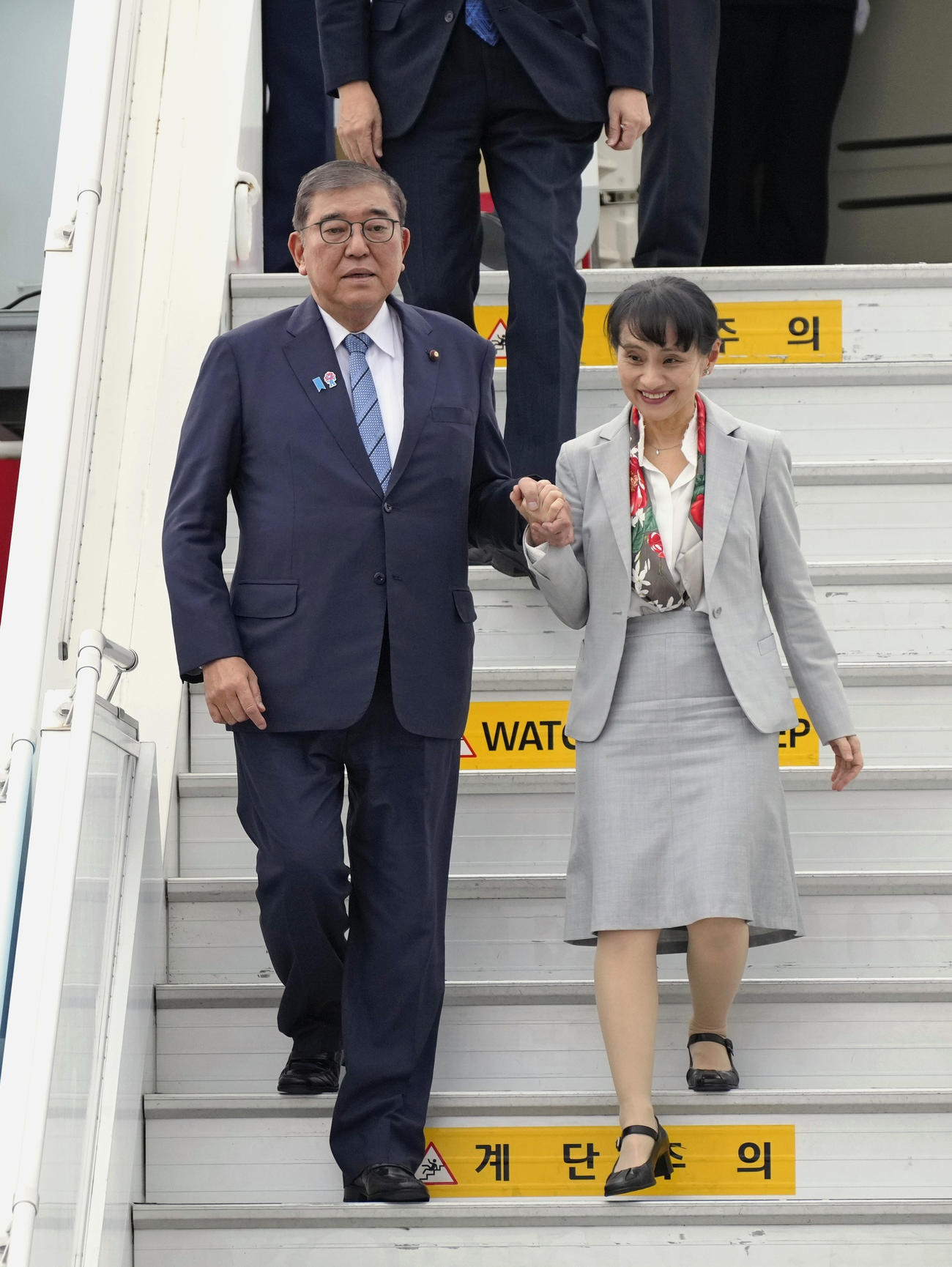 韓国・釜山の金海国際空港に到着した石破首相（。右は妻の佳子さん（共同）
