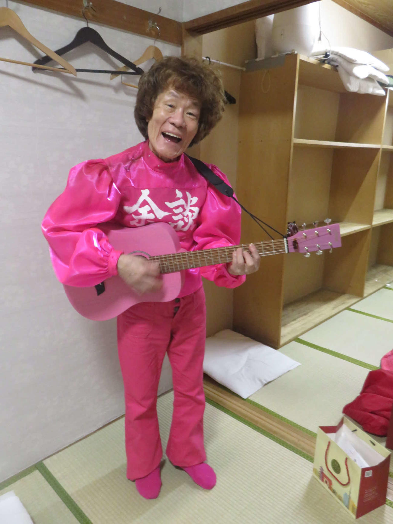 火事見舞いにEDWINが届けてくれたピンクのジーンズに春風亭小朝がくれたギターを持つ林家ペー（東京・浅草演芸ホールの楽屋で）