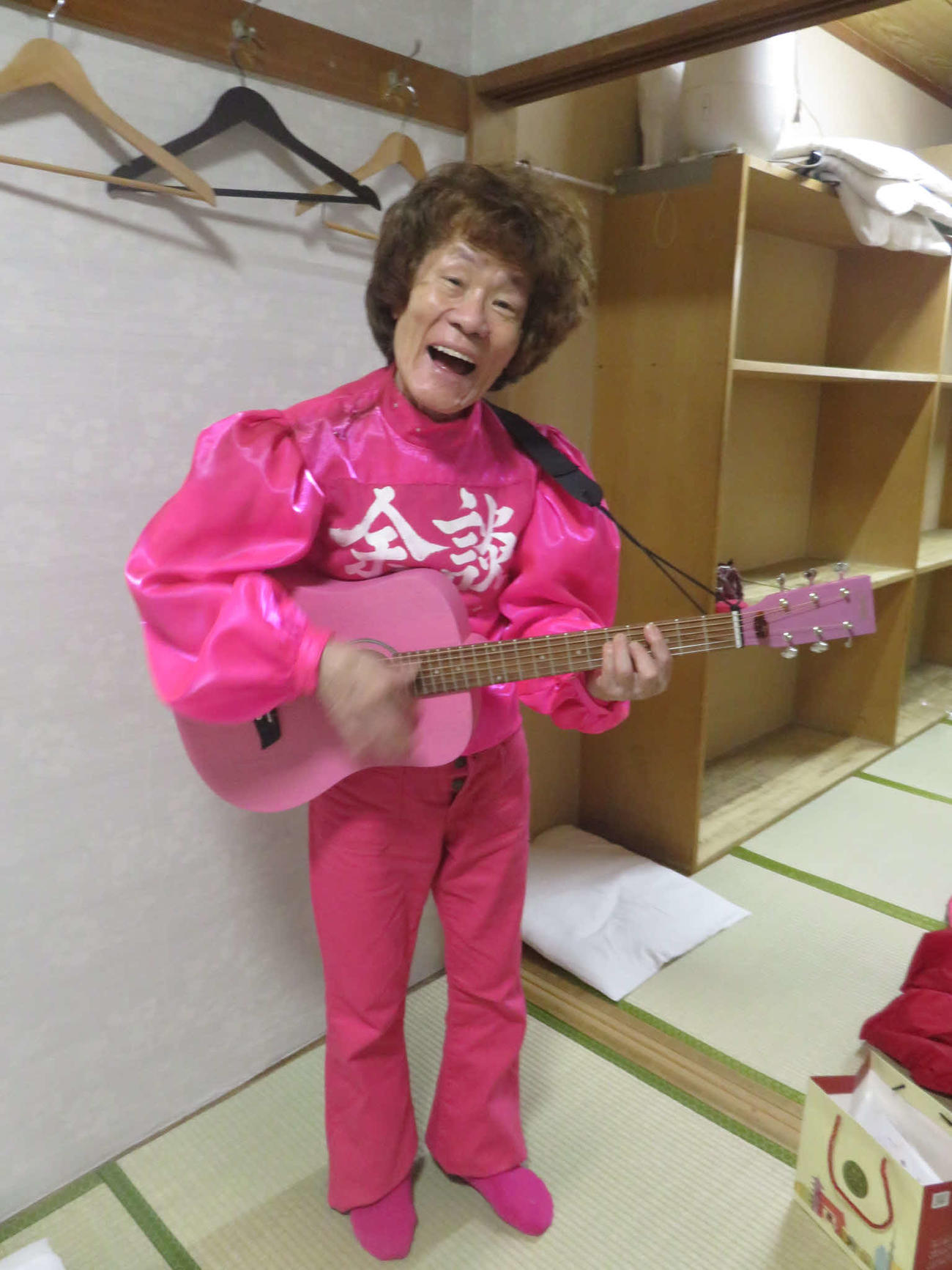 火事見舞いにEDWINが届けてくれたピンクのジーンズに春風亭小朝がくれたギターを持つ林家ペー（東京・浅草演芸ホールの楽屋で）