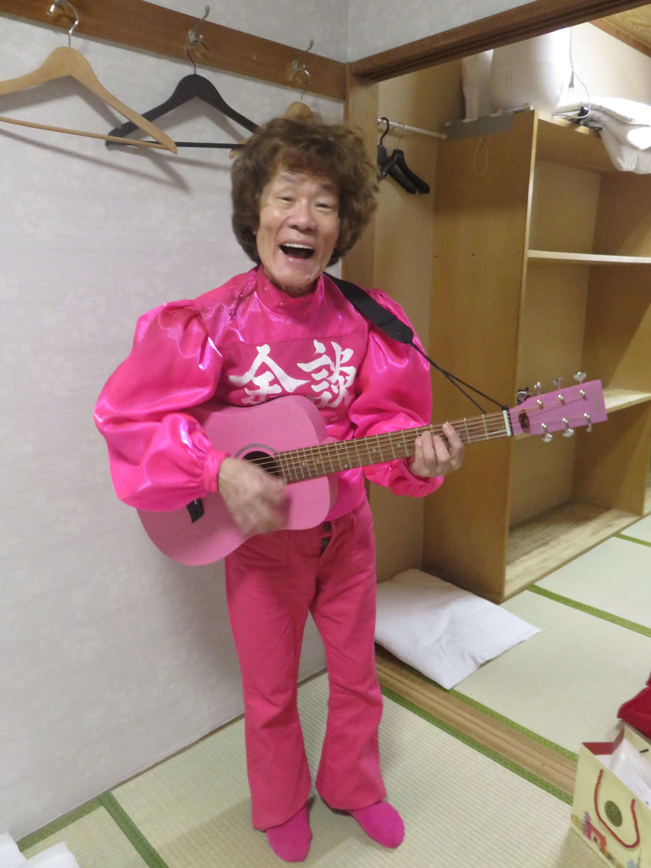 火事見舞いにEDWINが届けてくれたピンクのジーンズに春風亭小朝がくれたギターを持つ林家ペー（東京・浅草演芸ホールの楽屋で）