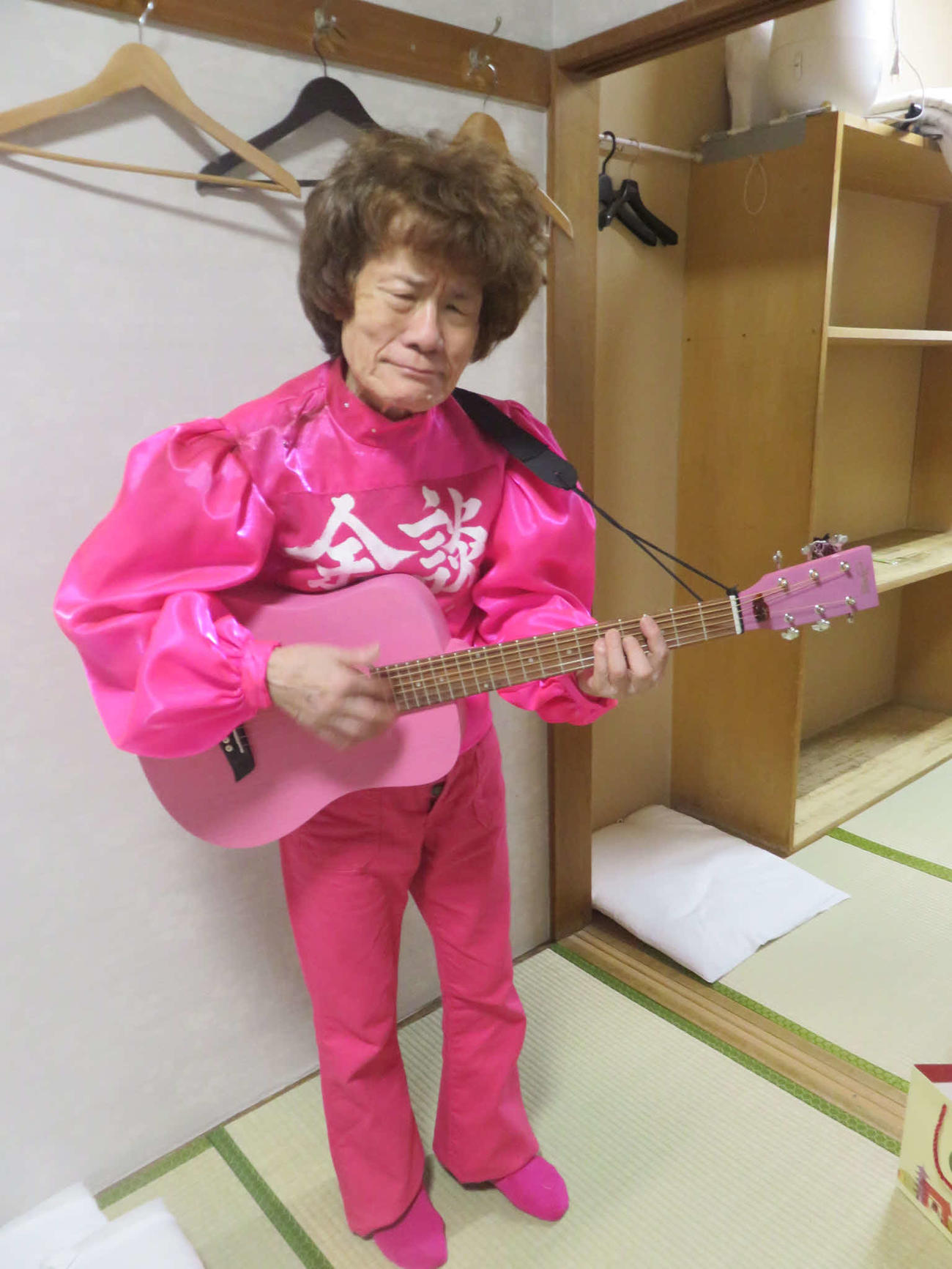 火事見舞いにEDWINが届けてくれたピンクのジーンズに春風亭小朝がくれたギターを持つ林家ペー（東京・浅草演芸ホールの楽屋で）