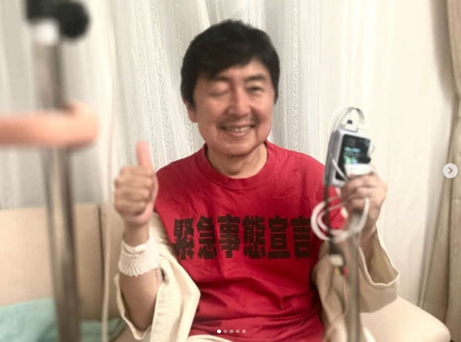 携帯心電図装置を手にする笠井信輔