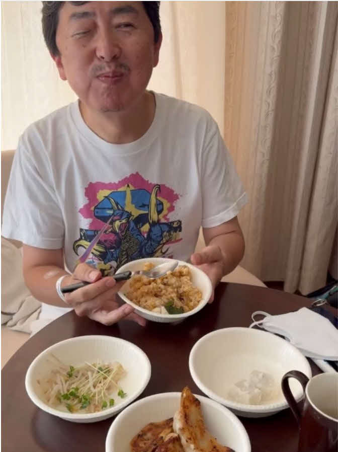 病室で妻茅原ますみが作ってきてくれたチャーハンとギョウザを食べ、笑顔の笠井信輔