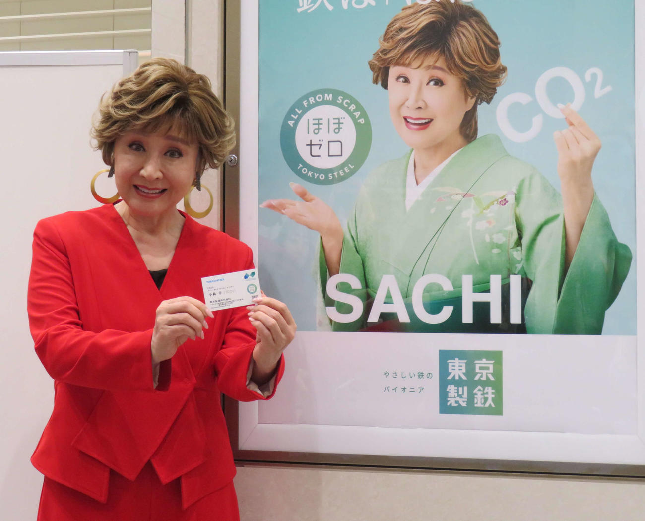 電炉鉄鋼メーカー「東京製鐵」の「ほぼゼロ」キャンペーンで作った名詞を差し出す小林幸子