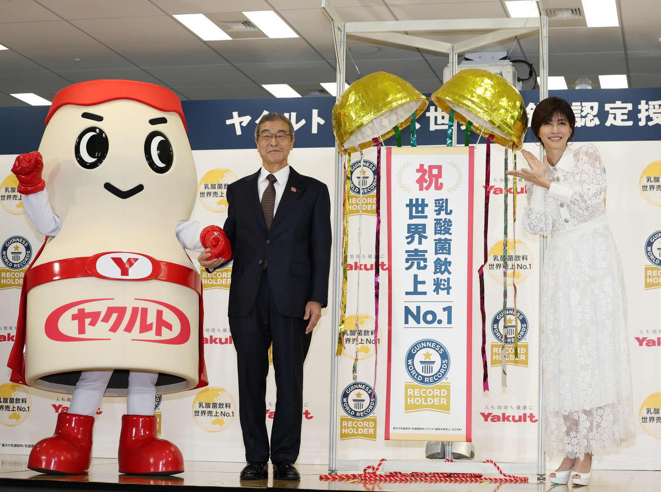 ギネス世界記録認定授与式でくす玉を割り笑顔を見せる左からヤクルトマン、ヤクルト成田裕代表取締役社長、内田有紀（撮影・増田悦実）
