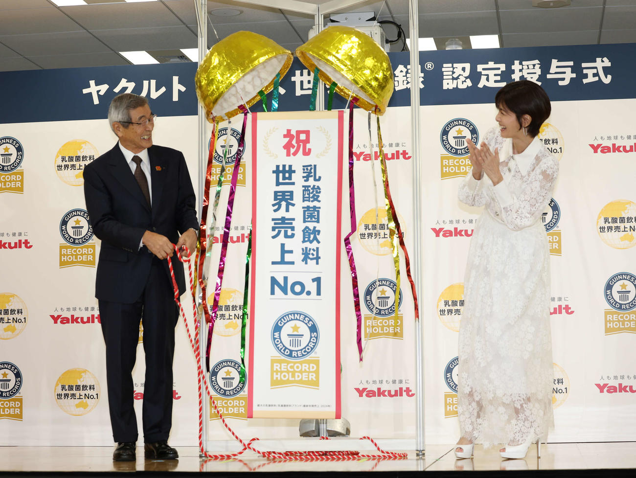 ギネス世界記録認定授与式でくす玉を割り笑顔を見せるヤクルト成田裕代表取締役社長（左）と内田有紀（撮影・増田悦実）