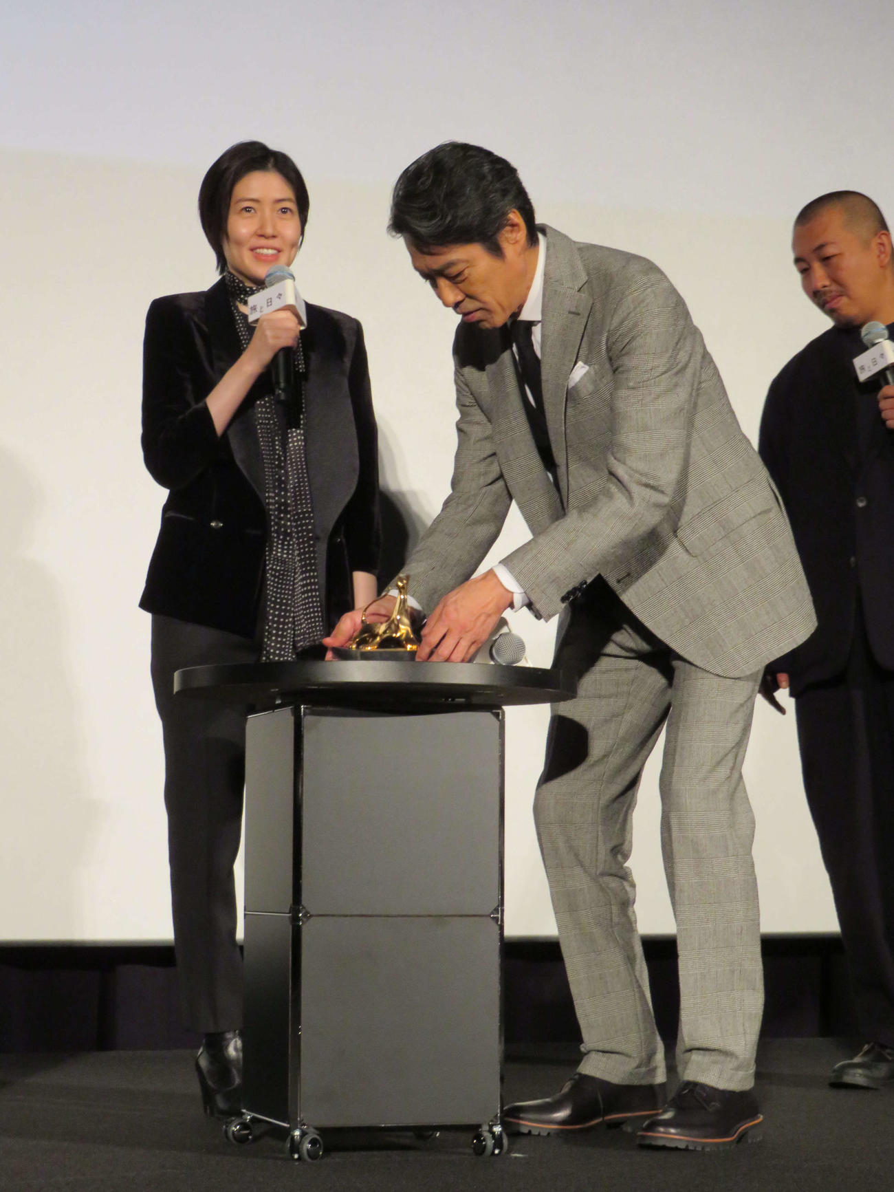 映画「旅と日々」ジャパンプレミアで、ロカルノ映画祭金豹賞のトロフィーを見つめるシム・ウンギョンと、持ち上げる堤真一（撮影・村上幸将）
