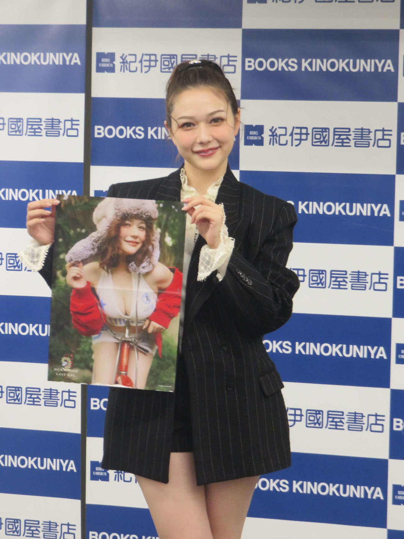 自身のピンナップを手にする村重杏奈