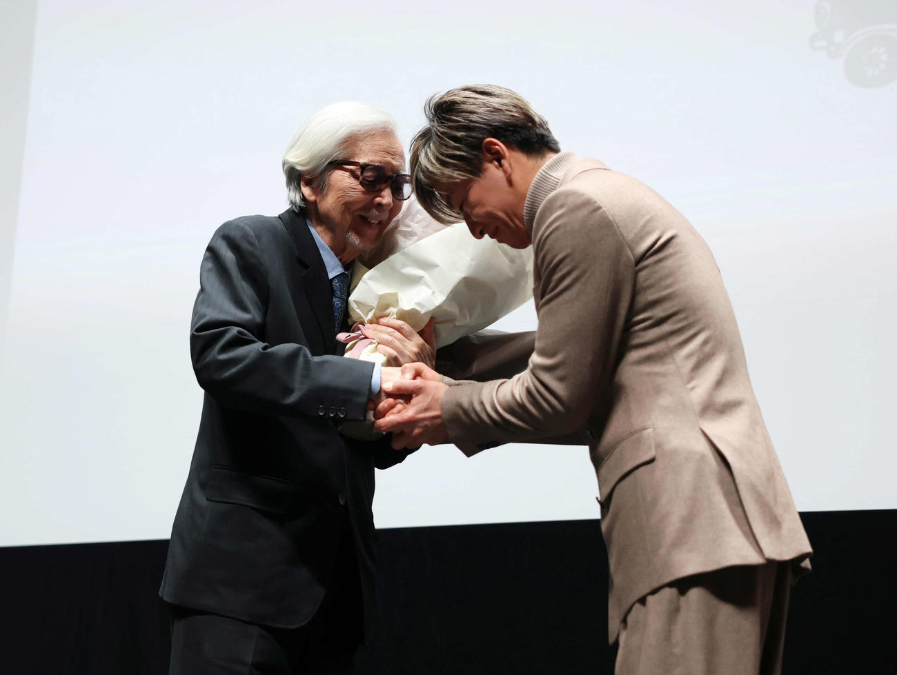 ＜センターピース上映＞で特別功労賞授与された山田洋次監督（左）に花束を渡し握手を交わす木村拓哉（撮影・増田悦実）
