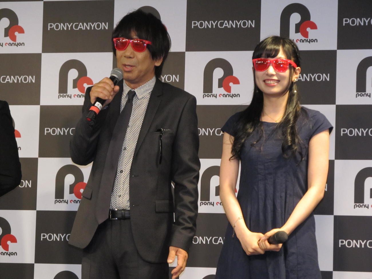 木根尚登（左）還暦・ソロ活動25周年記念舞台「何はともあれ、聴いてください！」制作発表会見で赤いサングラスをプレゼントされた高宗歩未（2017年5月16日撮影）