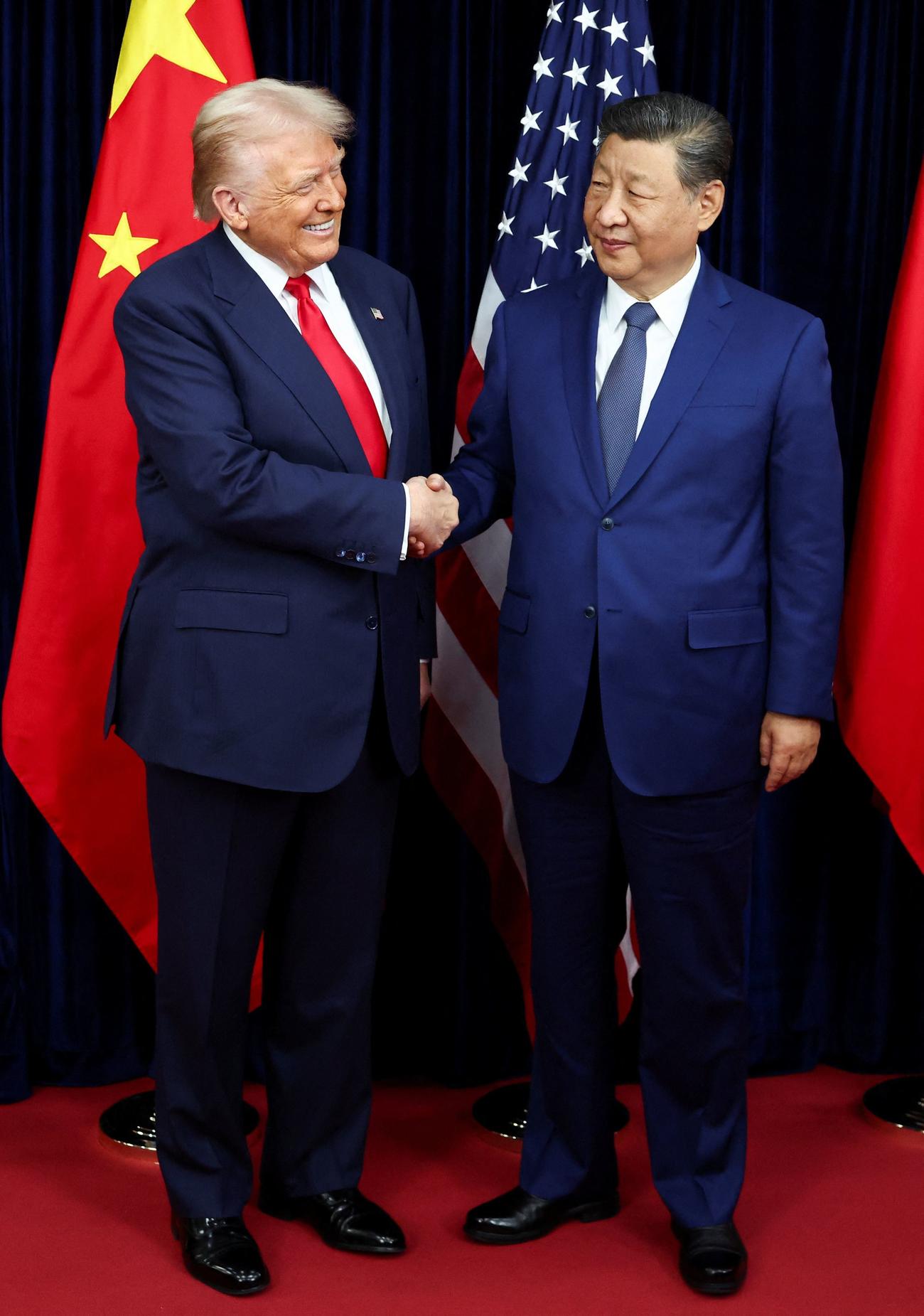 会談前に握手を交わすトランプ米大統領（左）と中国の習近平国家主席（ロイター＝共同）