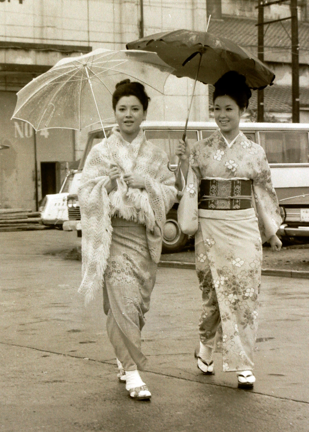 1968年5月、映画「不信のとき」の撮影で傘を差して移動する若尾文子（右）と岡田茉莉子