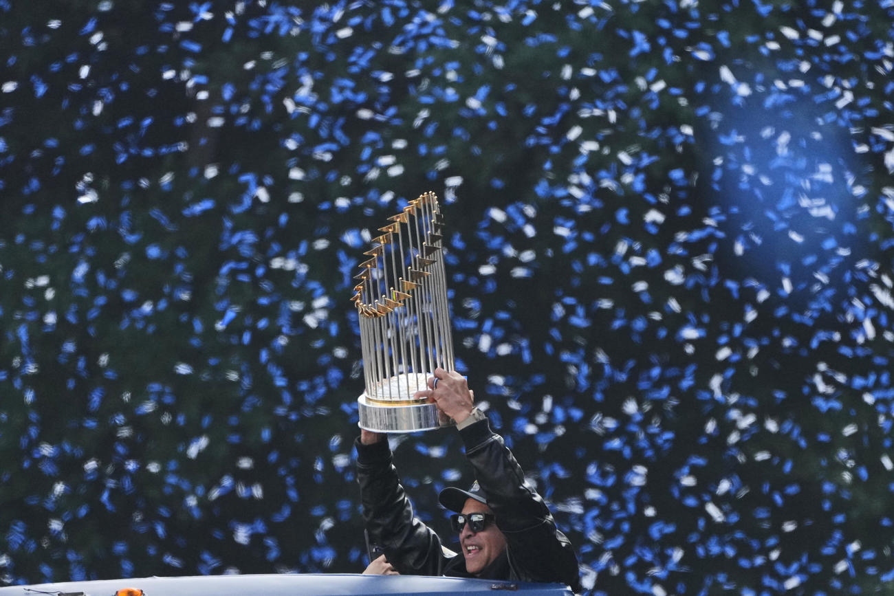 優勝パレードでWSトロフィーを掲げるドジャースのロバーツ監督（AP）