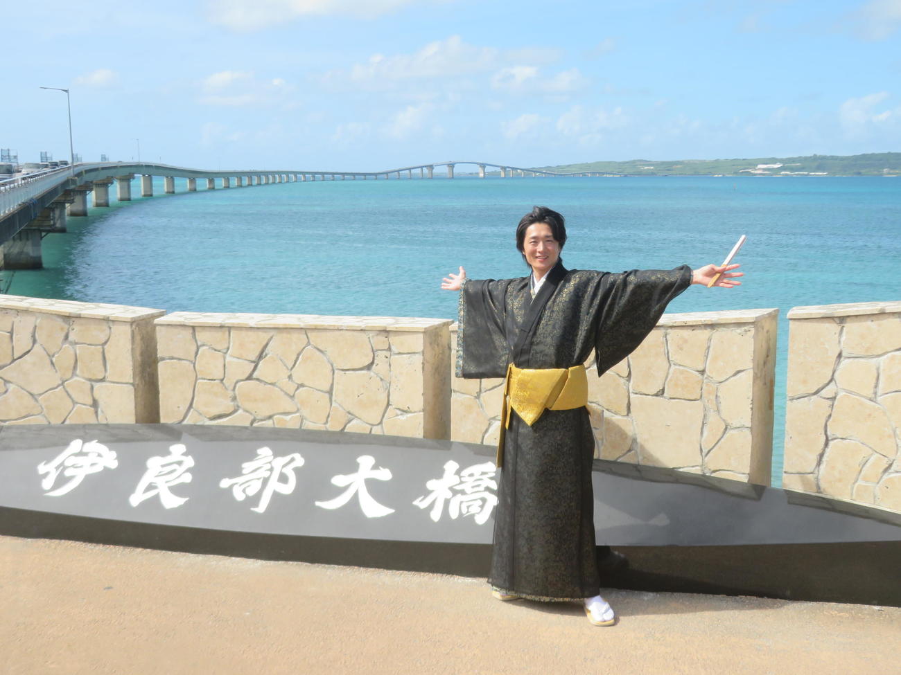 宮古島での初コンサート前に伊良部大橋を訪れ、琉装で写真に収まる真田ナオキ（撮影・川田和博）