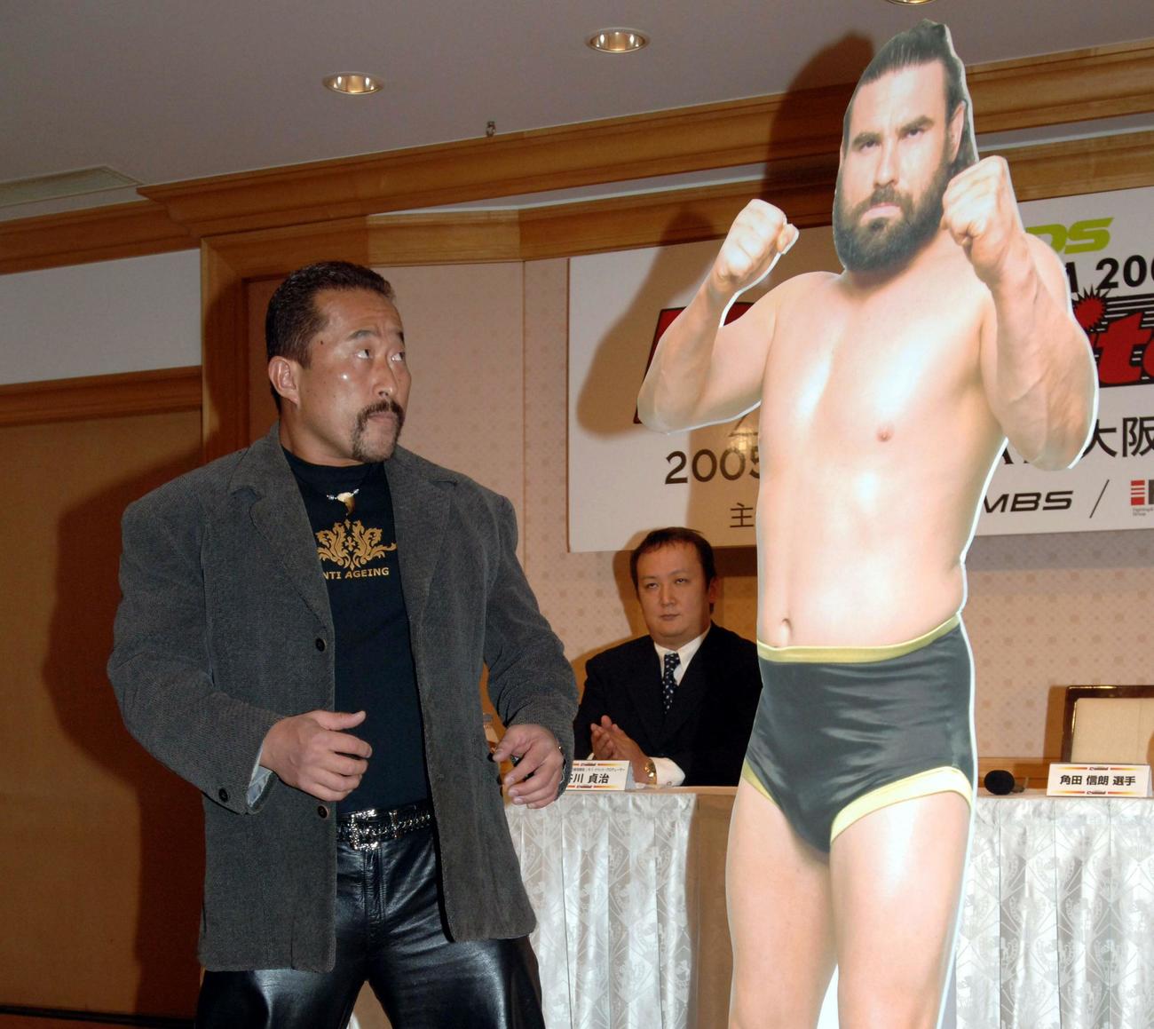 2005年12月、K−1 Dynamite記者会見　会見場に登場した角田信朗は、対戦相手に決まったザ・プレデターのパネルを見つけると、いきなりパンチを見舞う