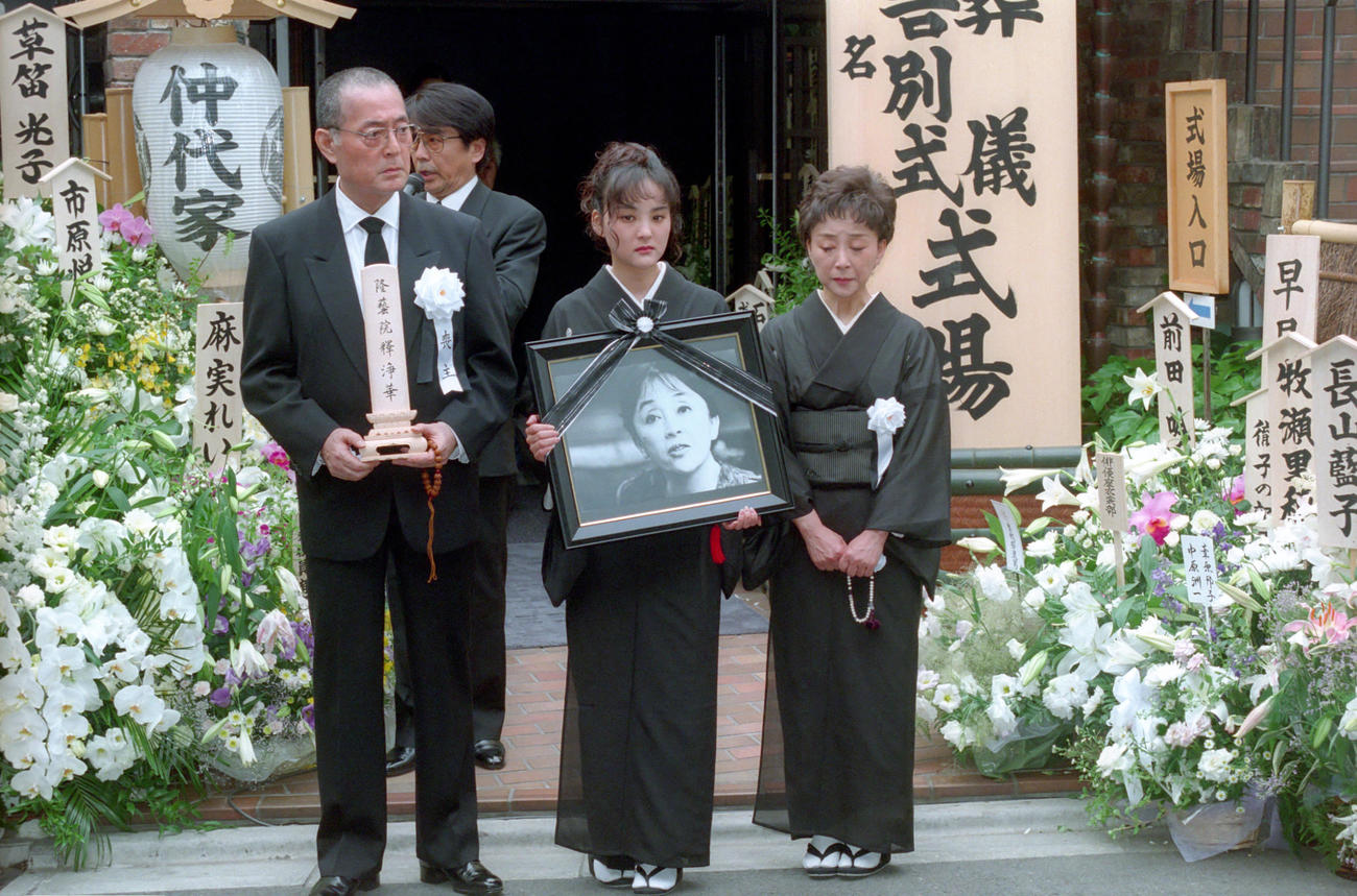 96年、妻隆巴(仲代恭子）さんの位牌を手にする仲代達矢さん（左）。娘の仲代奈緒(中央）は遺影を持ち出棺を見つめていた。右は恭子さんの妹の宮崎総子さん
