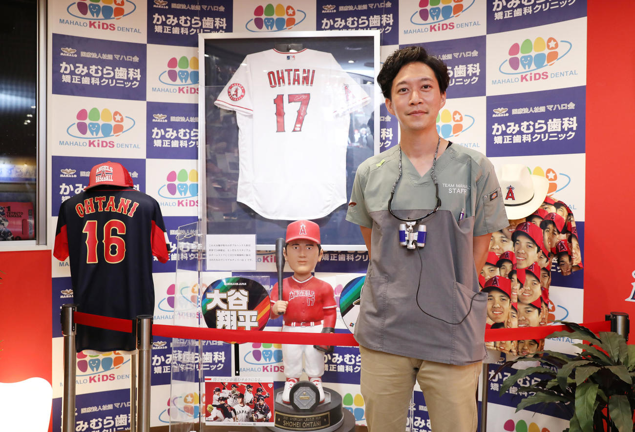 エンゼルス大谷が使用したアイテムなどが多数展示されたかみむら歯科の待合室で笑顔を見せる上村院長（2023年9月20日撮影）