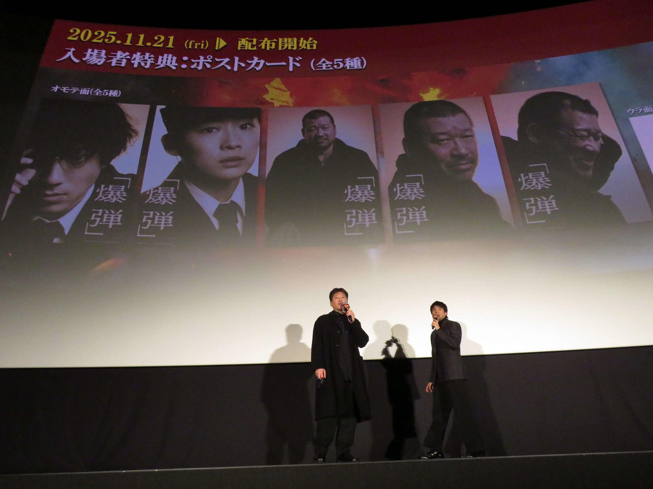 映画「爆弾」大ヒット御礼舞台あいさつで、スクリーンに映った入場者プレゼントの画像を見て語り合う佐藤二朗（左）と山田裕貴（撮影・村上幸将）