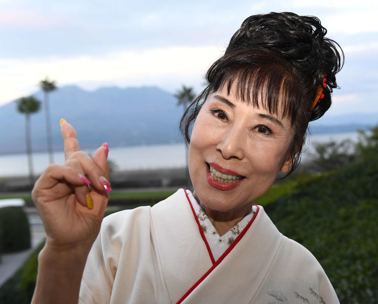 櫻島をバックにポーズを決める原田悠里
