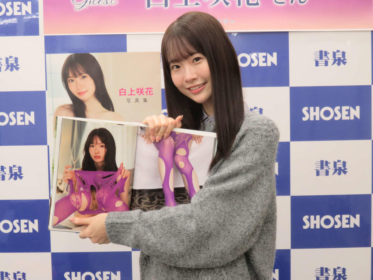 「白上咲花写真集　Blooming」のお気に入りのページを披露する白上咲花
