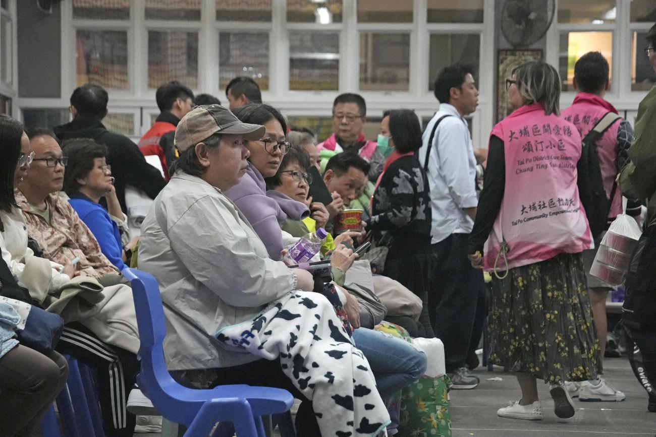 香港の高層住宅群で起きた大規模火災で、避難所の中学校に身を寄せる人たち＝26日（共同）
