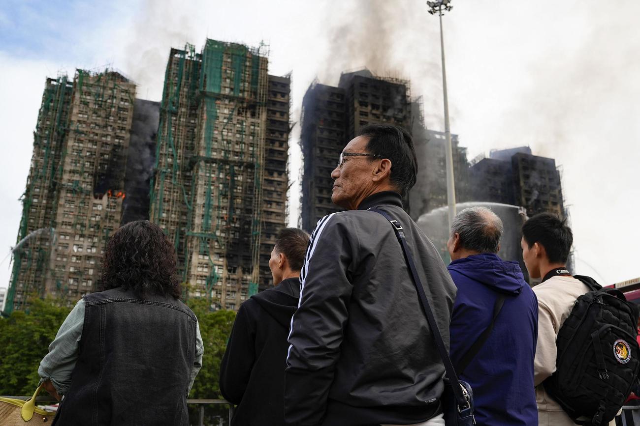 消化活動が続く火災現場の高層住宅を見つめる市民ら（共同）