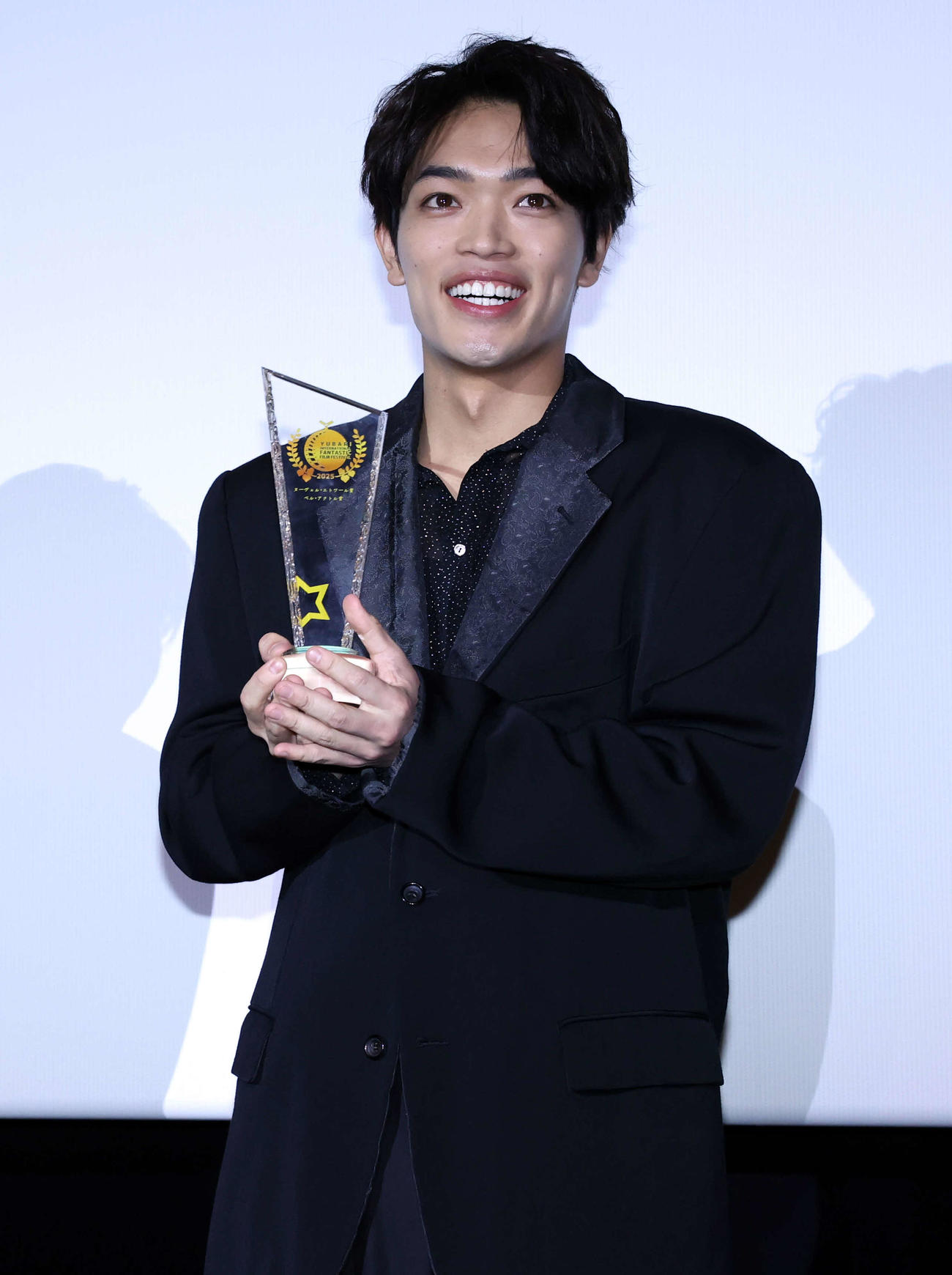 映画「初恋芸人」先行プレミア試写会舞台あいさつで、ゆうばり国際ファンタスティック映画祭からのトロフィーを授与され笑顔の原嘉孝（撮影・浅見桂子）
