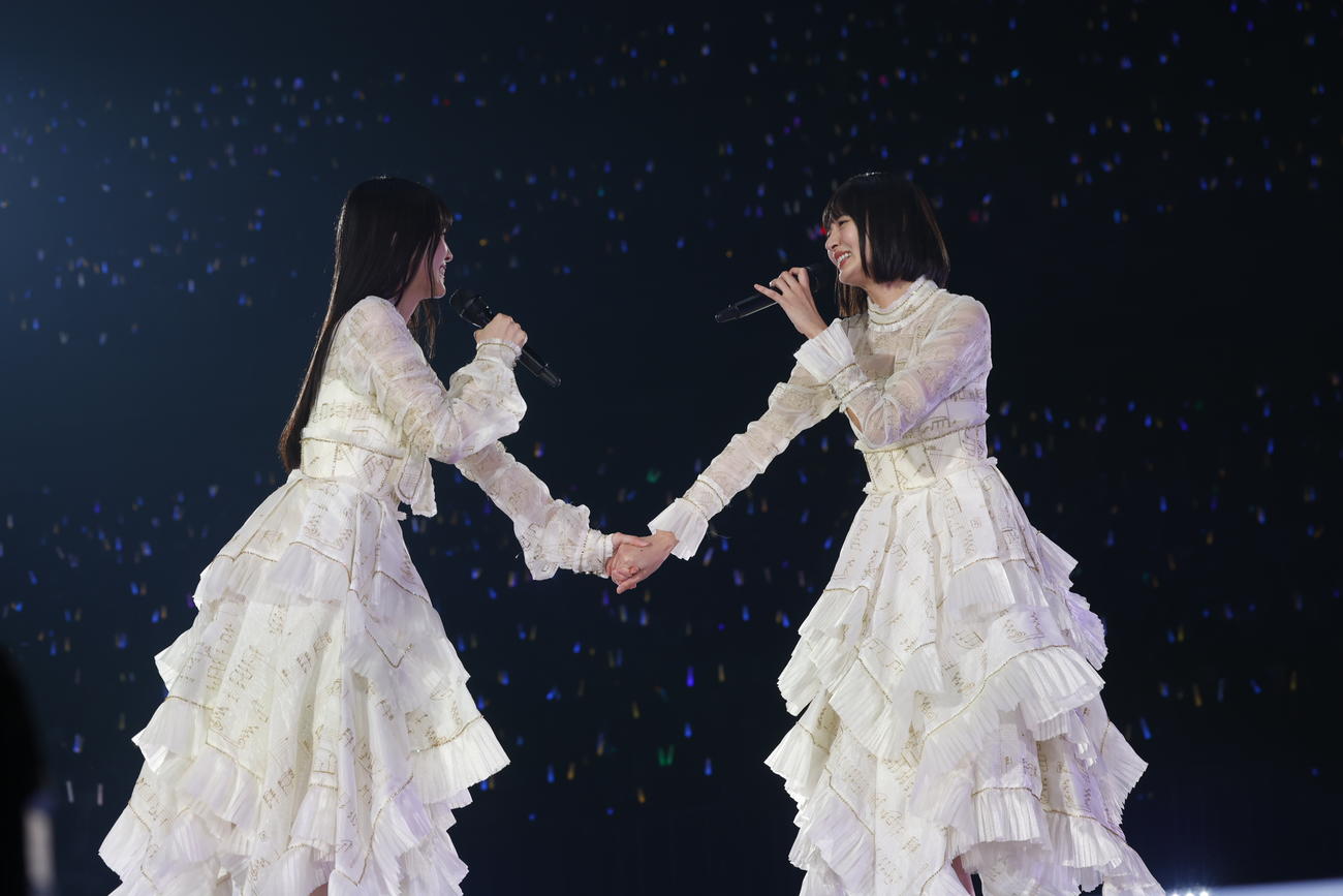 乃木坂46卒業コンサートで5期生とパフォーマンスする久保史緒里（左）。右は遠藤さくら(KENTA Inc.）