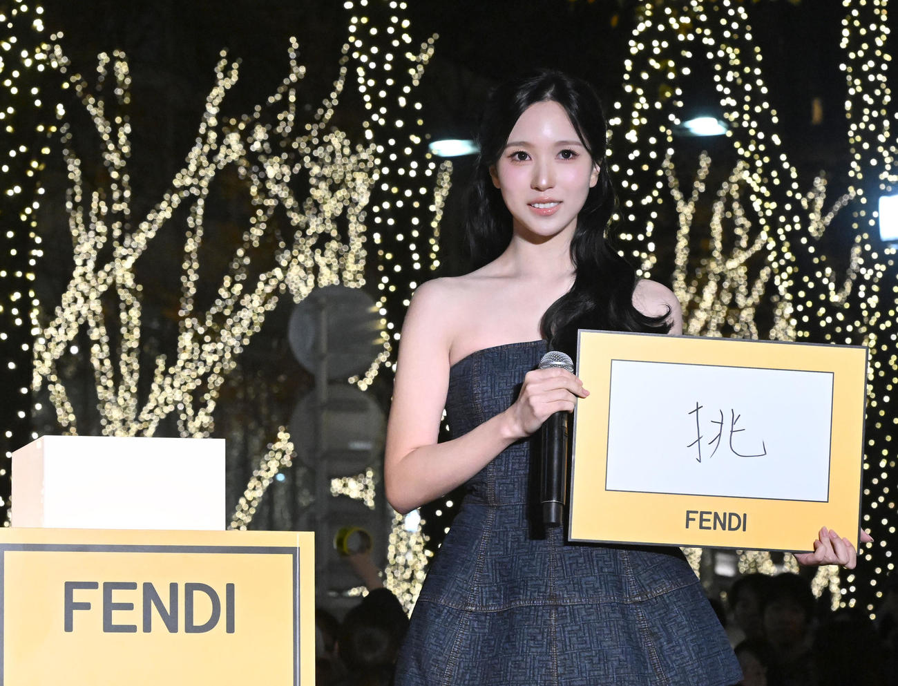 ケヤキ並木のイルミネーション点灯式で今年の漢字一文字を書いたパネルを披露したMINA（撮影・千葉一成）