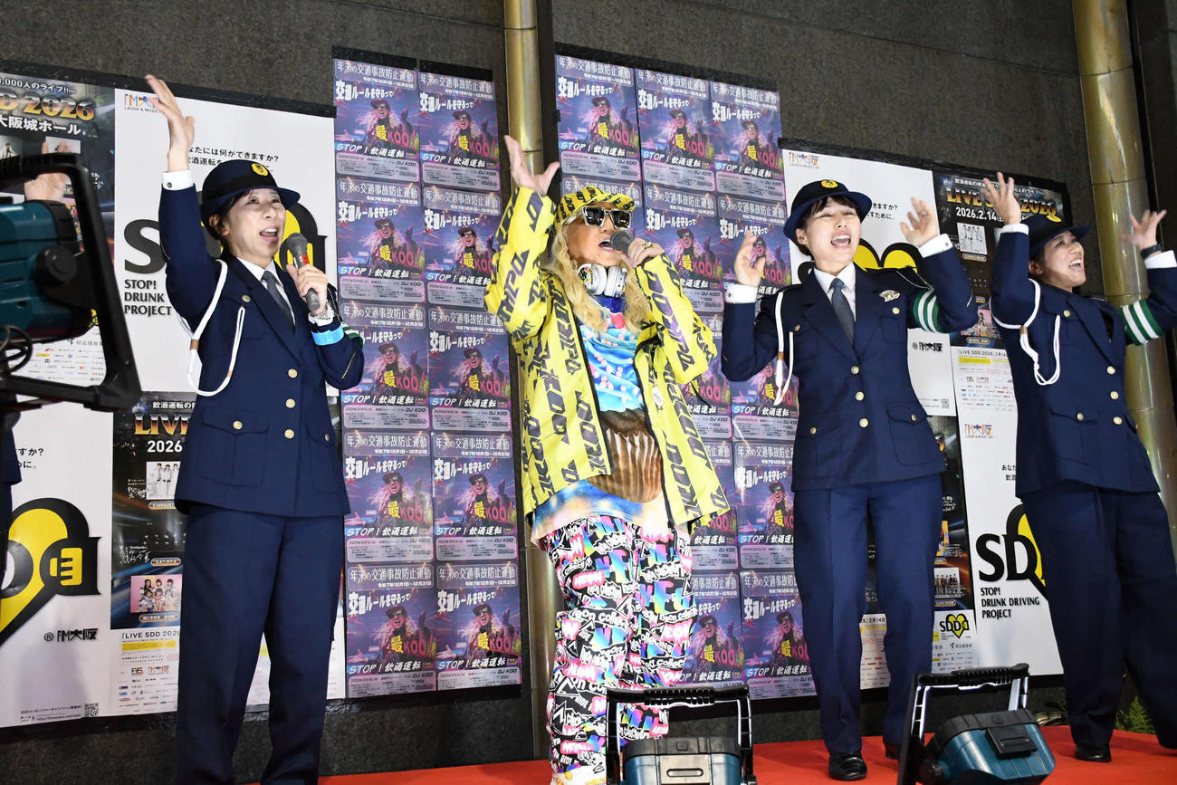 大阪府警の「年末の交通事故防止運動」啓発キャンペーンで警察官とともに啓発オリジナルソングを歌うDJ KOO（撮影・阪口孝志）