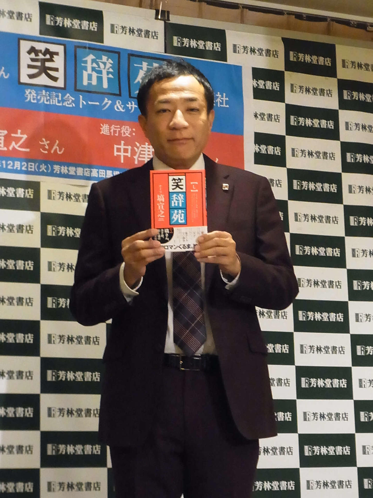 著書「笑辞苑」を手にするナイツ塙宣之