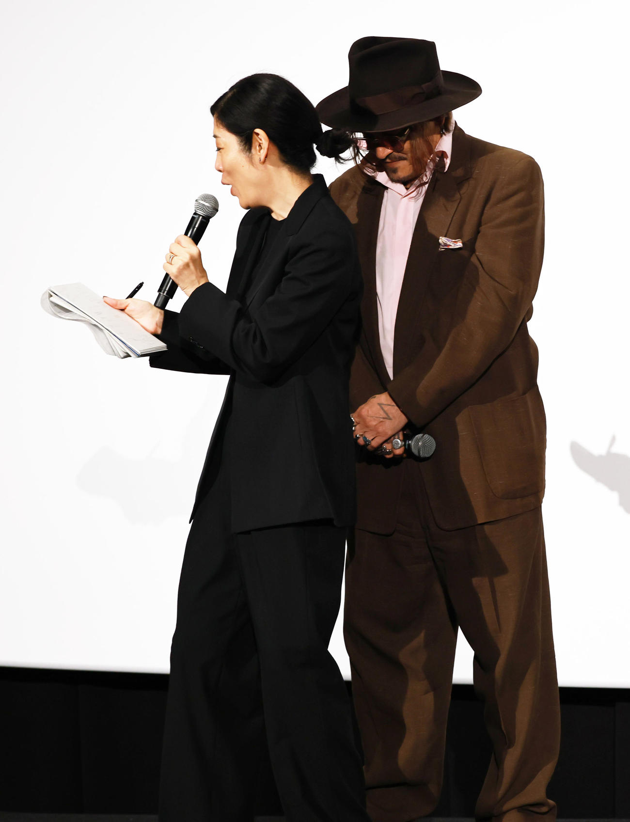 映画「モディリアーニ！」ジャパン・プレミアに登場し通訳の背後に隠れるジョニー・デップ（撮影・野上伸悟）
