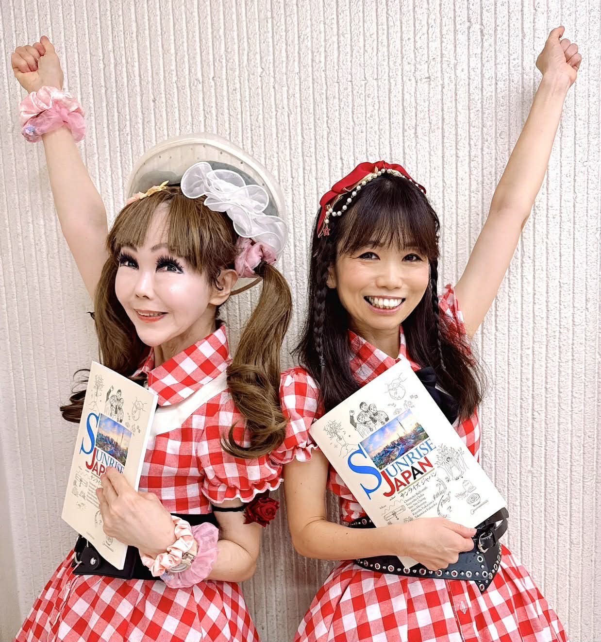 大学英語教科書「Sunrise Japan」を手にする、ミリオンキッスの恵中瞳（左）とカンパーニュ楓