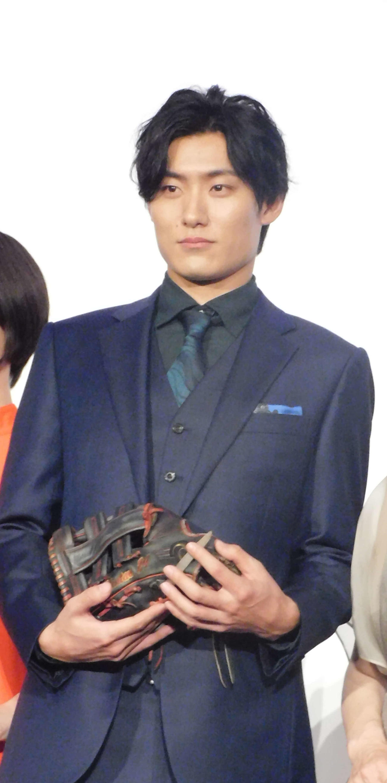 横田慎太郎さんから譲り受けたグローブを大事に持つ松谷鷹也（撮影・寺本吏輝）