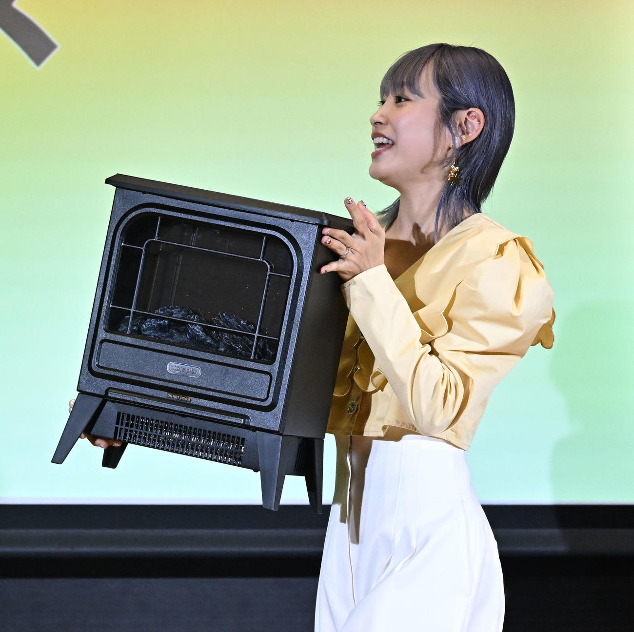 「Pikaでんきローンチイベント」であべこうじにクリスマスプレゼントの電気暖炉を用意した高橋愛（撮影・千葉一成）