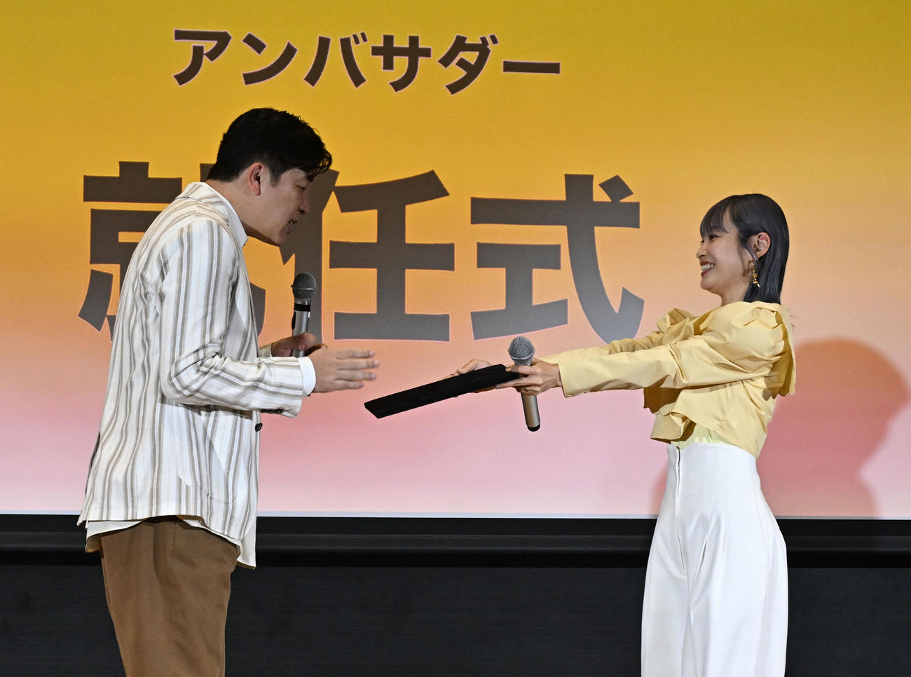 「Pikaでんきローンチイベント」であべこうじにアンバサダー任命書を手渡す高橋愛（撮影・千葉一成）