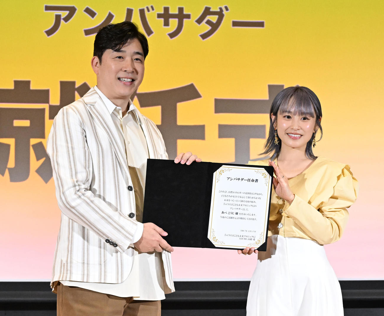 「Pikaでんきローンチイベント」でアンバサダー任命書を手に写真撮影に応じるあべこうじと高橋愛夫妻（撮影・千葉一成）