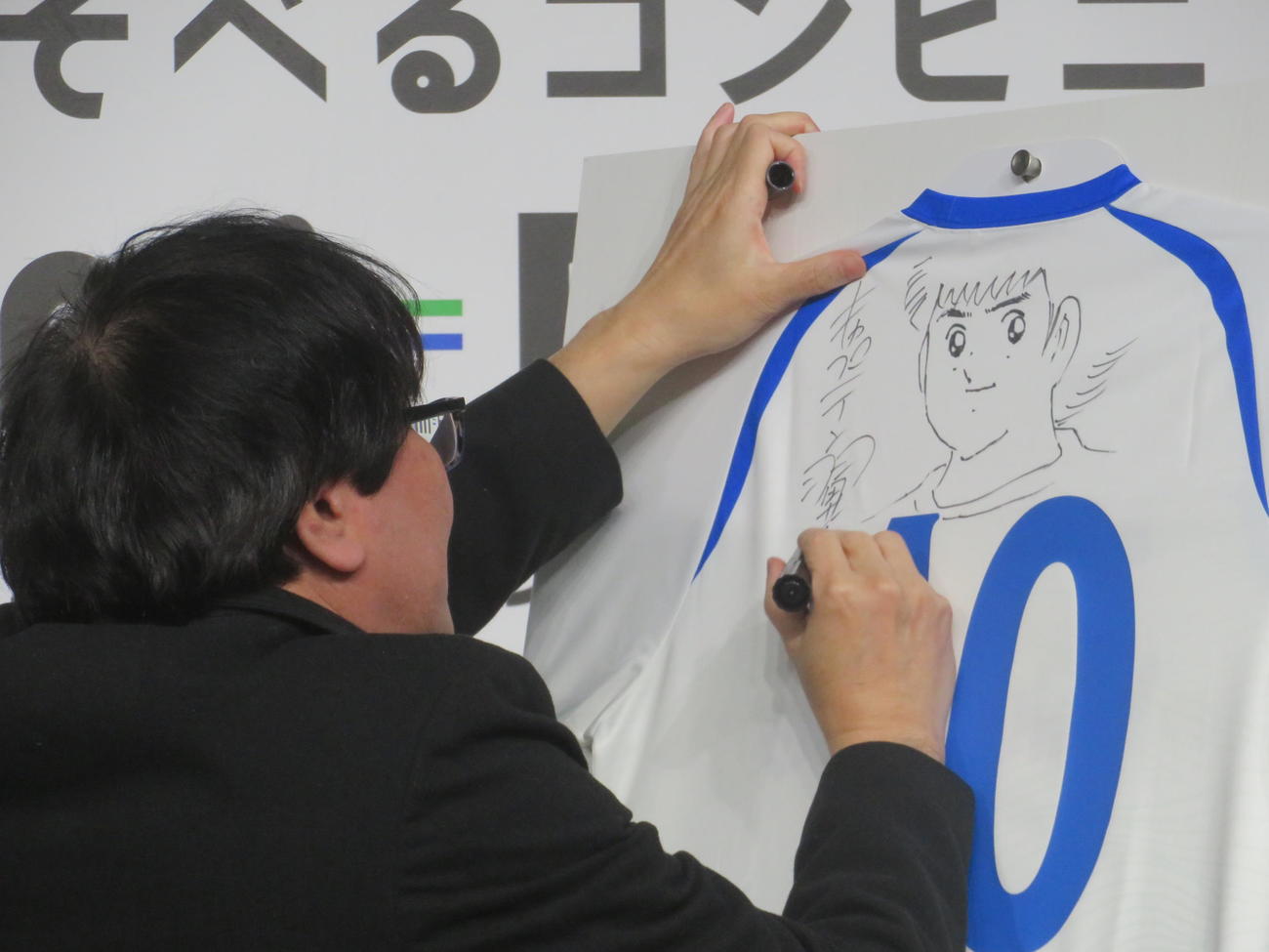 「ファミフェス2025」発表会でライブドローイングを披露する高橋陽一氏（撮影・川田和博）