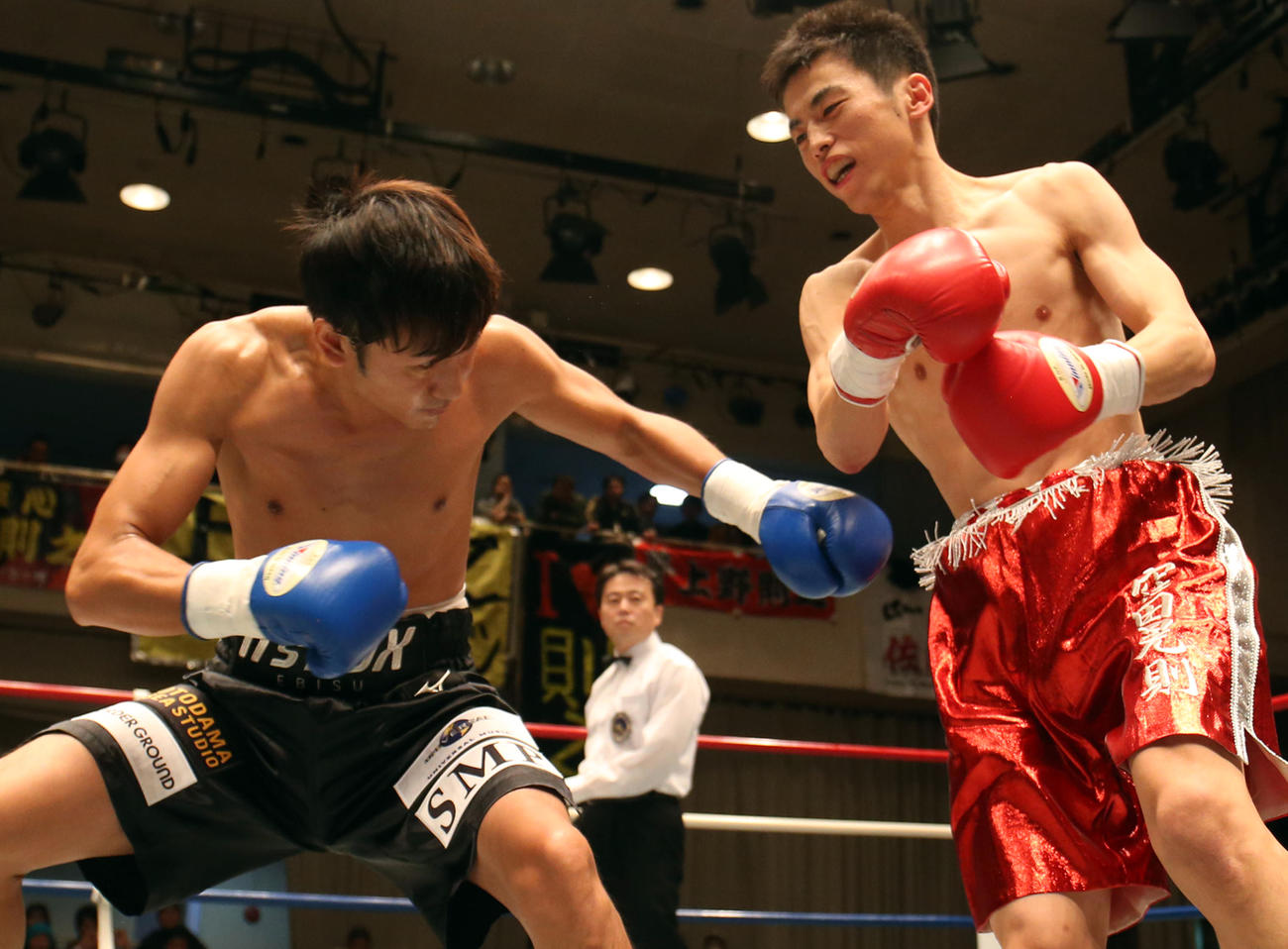 2013年11月、プロボクサーデビュー戦　窪田晃則対榑井勇輝　1回、窪田晃則（右）にパンチを放つキマグレンのKUREI