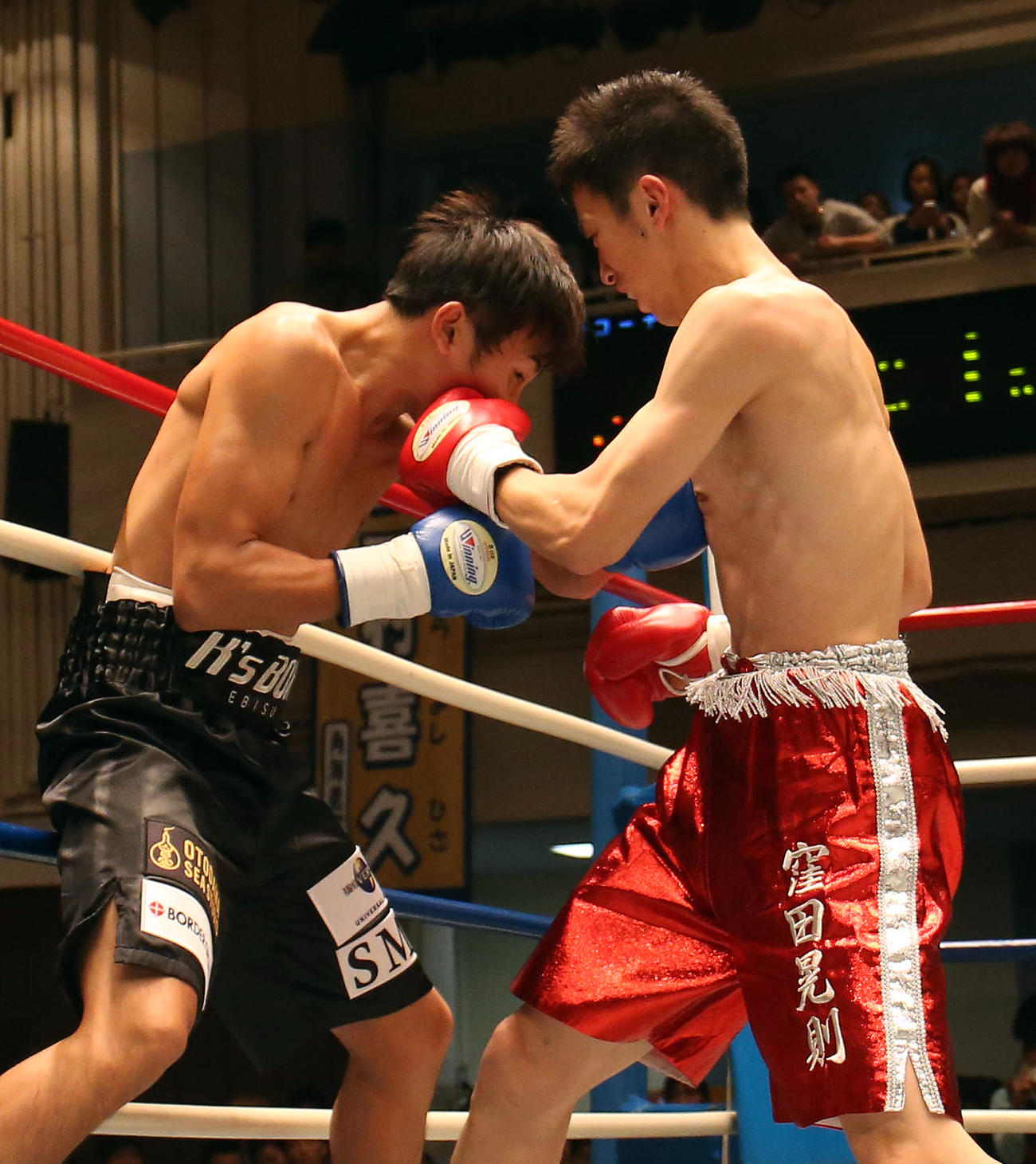 2013年11月、プロボクサーデビュー戦　窪田晃則対榑井勇輝　1回、窪田晃則（右）のパンチを浴びるキマグレンのKUREI