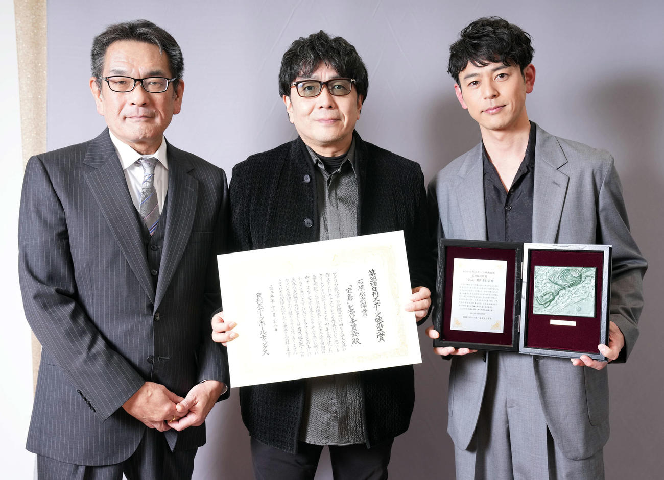石原裕次郎賞を受賞し記念撮影に納まる、大友啓史監督（中央）と妻夫木聡。左はプレゼンターの石原邦彦社長（撮影・たえ見朱実）
