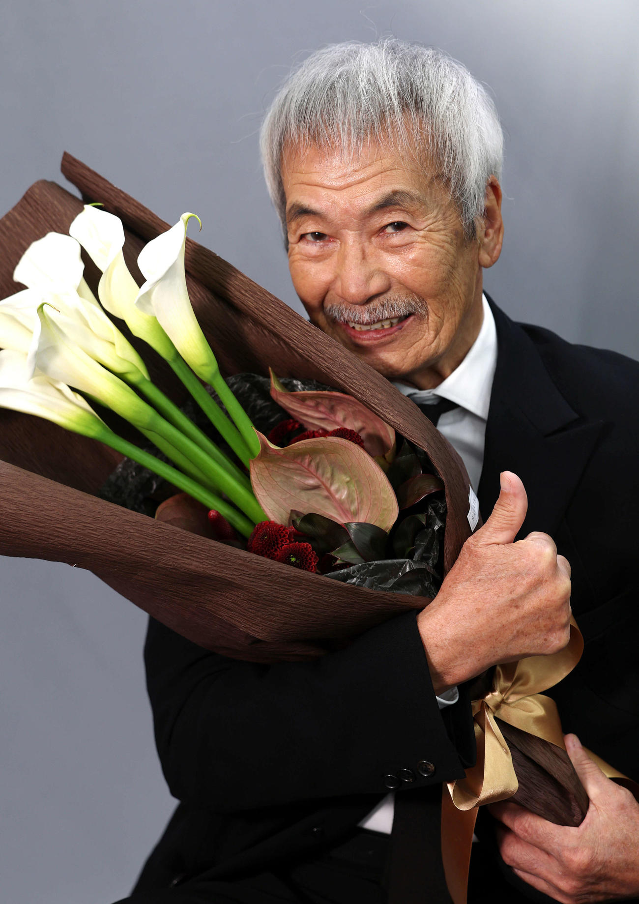 助演男優賞を受賞した田中泯は花束を手にサムズアップ（2025年12月撮影）