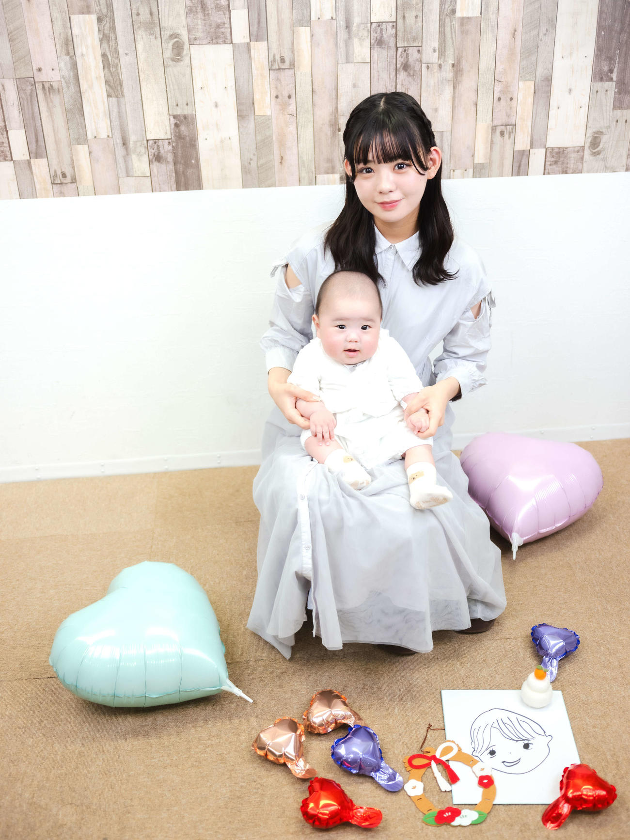 元AKB48宮里莉羅インタビュー　赤ちゃんと写真に納まる宮里莉羅。右下は夫の似顔絵＝2025年12月25日