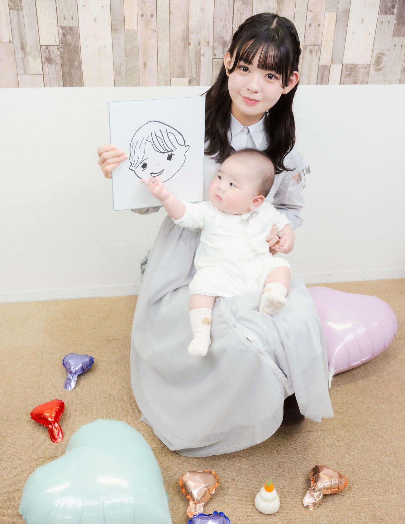 元AKB48宮里莉羅インタビュー　夫の似顔絵を手に赤ちゃんと写真に納まる宮里莉羅＝2025年12月25日